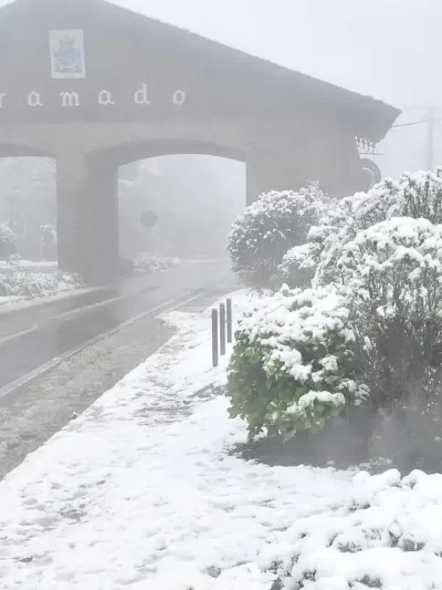 Imagem do pórtico de Gramado coberto de neve em 2025 durante frente fria histórica.